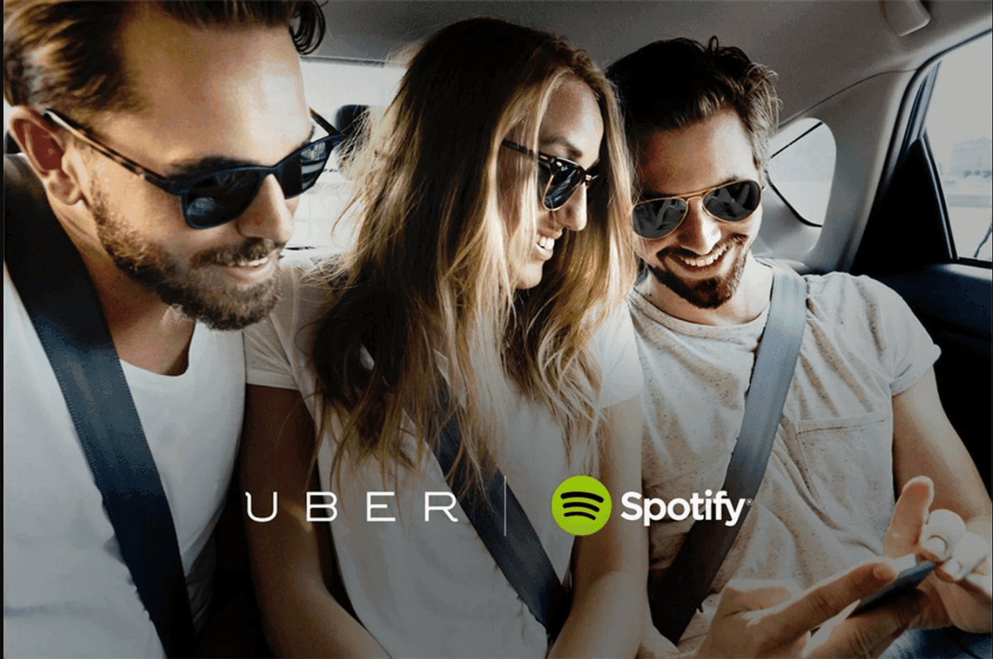 A photo of three people in a car, promoting the UBER and Spotify partnership.
