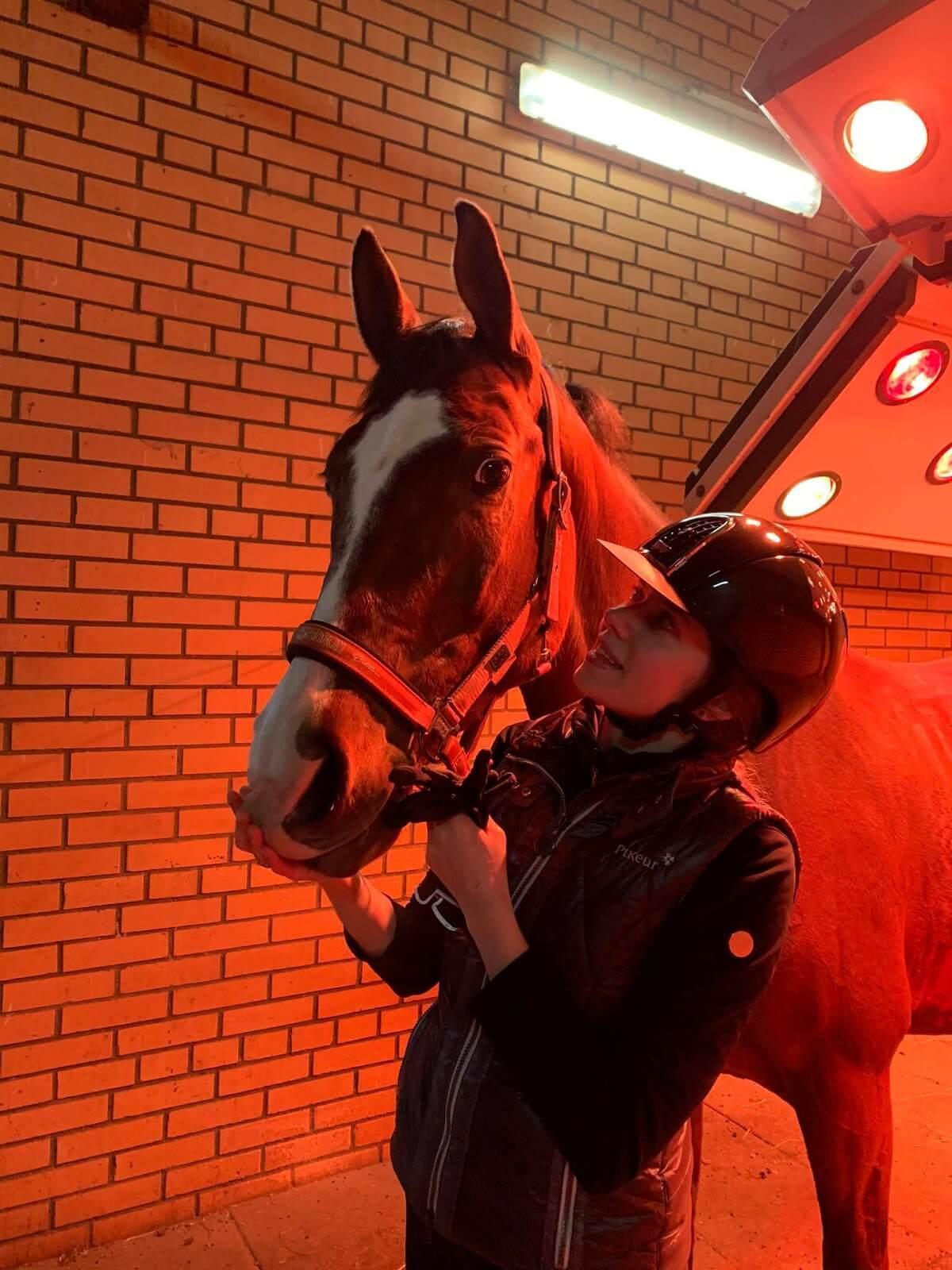 A photo of the author (Alexandra) with a horse